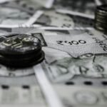 A detailed close-up of Indian currency notes and coins, highlighting financial themes.